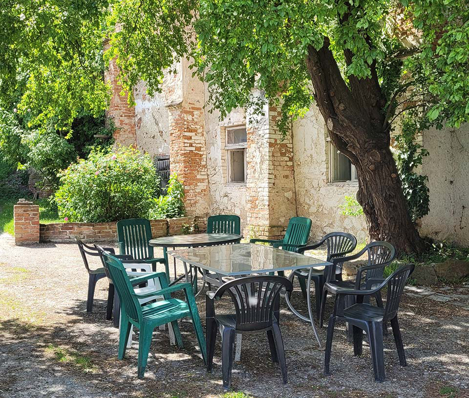 Hier sieht man einen gemütlichen Tisch mit Stühlen im Freien